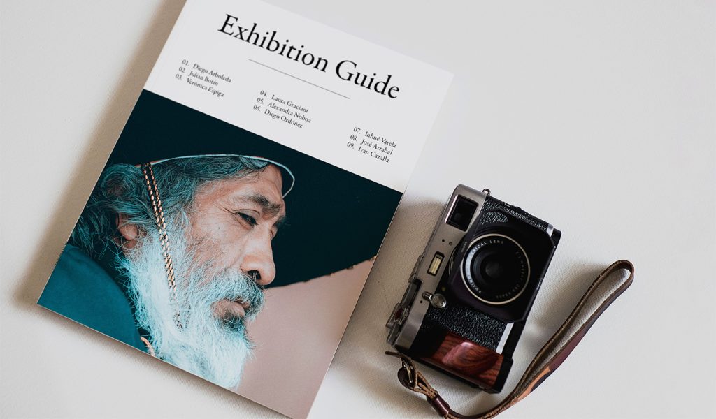 Exhibition guide featuring diverse artists alongside vintage camera, illustrating how books showcase expertise and build authority