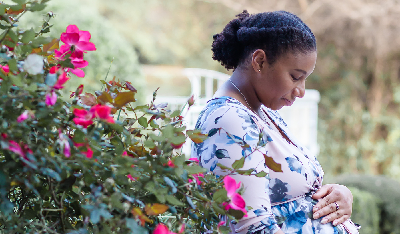 A pregnant woman surrounded by flowers