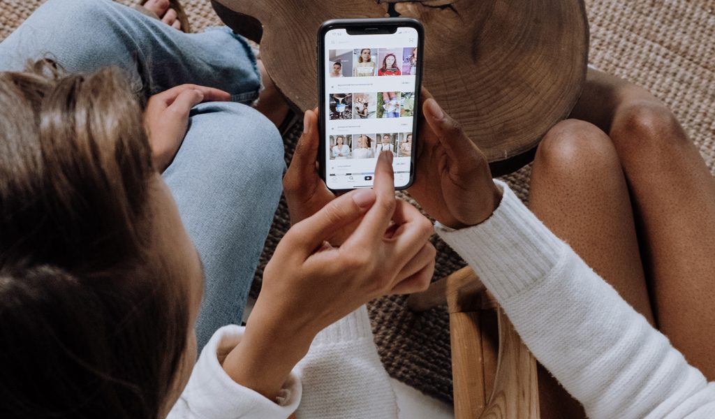 Two photographers looking at social media marketing on a phone