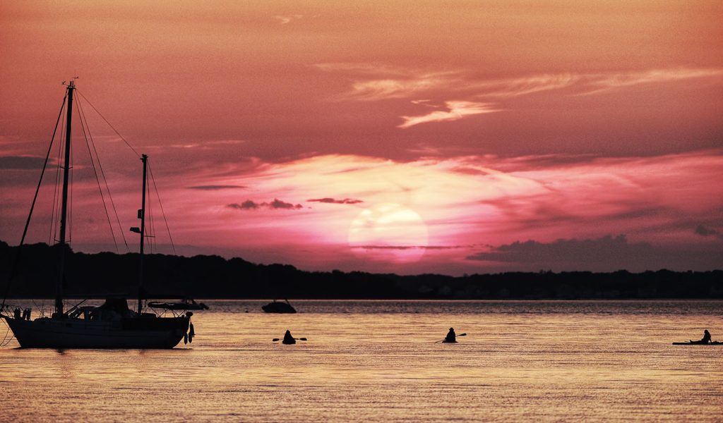 Snapshot of a sailboat sailing in the sunset.