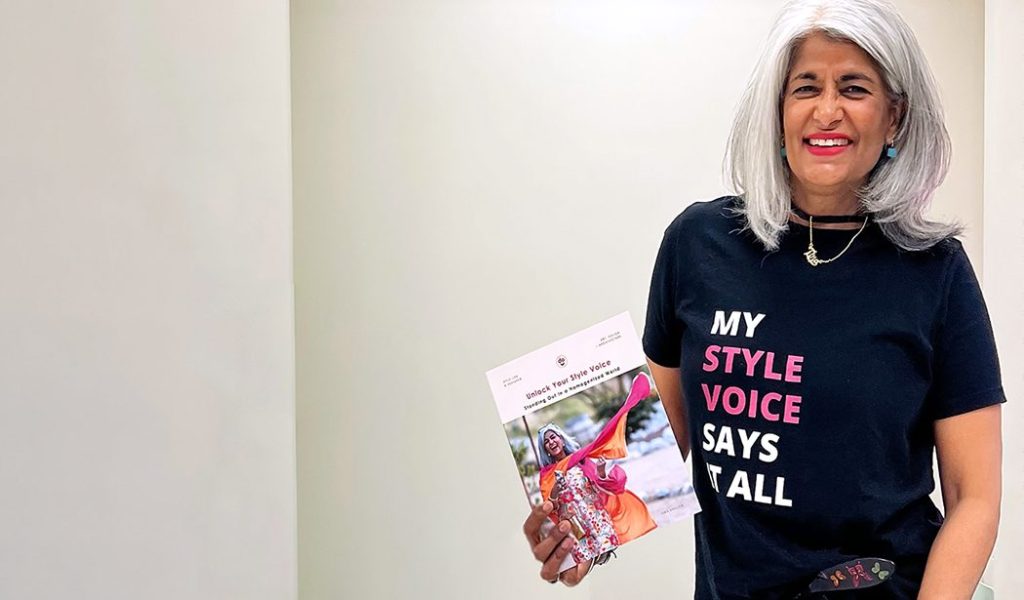 photo of self published author Tina Dhillon holding up her workbook, Unlock Your Style Voice