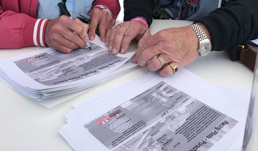 Jack Webster, auto racing photographer, getting signatures from legendary Porsche drivers to include in his self published book Racing Pilots which sold for a premium